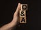 QA or Q concept. QnA acronym on wooden cubes on black background with copy space