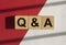 QA text on white and red background. QnA acronym. Q concept. Questions and answers