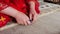 Qashqai woman in red cuts carpet while weaving closeup slow motion