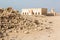 Qatar. The desert at coast of Persian Gulf. Abandoned mosque with minaret. Deserted village. Pile of stones