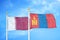 Qatar and Mongolia two flags on flagpoles and blue cloudy sky