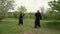 A qigong master and his disciple practice tai chi in nature in a park