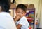 Qingyuan, China - June 23, 2016: A little curious Chinese boyis eating his meal and talking with his classmates