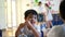 Qingyuan, China - June 23, 2016: A little curious Chinese boyis eating his meal and talking with his classmates