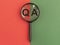 Qna inscription on red and green papersthrough magnifying glass. QA acronym. Q concept. Questions and answers