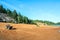 Quad ATV stands on sandy terrain at a beautiful lake.