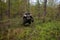 The quad bike jumps over the log in summer