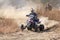 Quad Bike kicking up trail of dust on sand track during rally ra