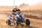 Quad Bike kicking up trail of dust on sand track during rally ra