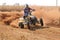 Quad Bike kicking up trail of dust on sand track during rally ra