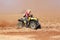 Quad Bike kicking up trail of dust on sand track during rally ra