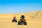 Quad driving people - two happy bikers in sand desert dunes, Africa, Namibia, Namib, Walvis Bay, Swakopmund.