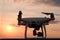 Quadcopter on the background of the sunset sky. Unmanned aerial vehicle preparing to fly.