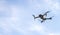 Quadcopter with digital camera flying over blue sky. bottom angle view