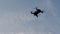 Quadcopter flies in the blue sky, drone shoots video