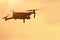 The quadcopter flies right at sunset, a modern quadcopter soars in the air