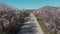 Quadrocopter shot old road with flowering almond