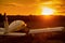 Quadruple aircraft parked at a private airfield. Rear view of a plane with a propeller on a sunset background.