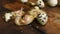 A quail chick hatches from an egg close-up on a wooden background.