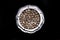 Quail eggs arranged in a silver dish, on a black background