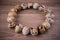 Quail eggs circle on wooden background