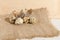 Quail eggs on a rough burlap cloth with beautiful feathers on a wooden surface background