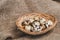 Quail eggs in a small homemade basket on a rough linen napkin