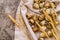 Quail eggs on a table linen with ears of wheat on dark textured background