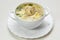 Quail soup with noodles and quail eggs in a white plate