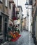 Quaint cobblestone alleyway in Aosta Italy with inviting red carpet entrance to Italian restaurant on left