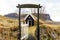 Quaint house captured through an outdoor archway with a beautiful rock mountain in the background