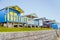 Quaint wooden beach huts in a row along a grass verge