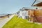 Quaint wooden beach huts in a row along a grass verge