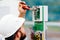 A qualified electrical engineer sets up a control and measuring device at an industrial facility on a summer day.