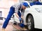 Qualified mechanic changes tires on car in car service