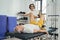 Qualified physical therapist employing a cable machine for leg rehabilitation