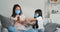 Quarantine and lockdown. Korean Asian Chinese mother and daughter wear medical masks on their faces child sprays