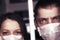 Quarantine. A sick man and woman in protective medical masks look through emotions on the face - fear, fright and panic