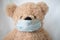 Quarantine, threat of coronavirus. Sad child and his teddy bear both in protective medical masks sits on windowsill and