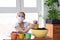 A quarantined girl pours earth into a pot for planting plants