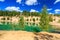 Quarry or lake or pond with sandy beach, green water, trees and hills with cloudly sky