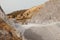 Quarry machines and piles of gravel over blue sky. Stone crushing and screening plant