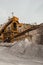 Quarry machines and piles of gravel over blue sky. Stone crushing and screening plant