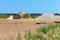 Quarry sand mining, truck and excavator next to a pile of sand