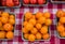 Quart of round orange cherry tomatoes on a checkerboard red and white tablecloth