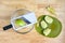 Quartered granny smith apple, green cutting board, and mandolin slicer on a butcher block table