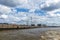 Quay of a port with cranes and construction sites, cloudy blue s