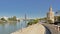 Quays of Guadalquivir river, with historical Torre del Oro, and modern Seville tower