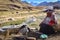 A Quechua lady dyeing Alpaca Wool for textile making. Chillca, Cusco, Peru