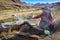 A Quechua lady dyes Alpaca Wool for textile making. Chillca, Cusco, Peru